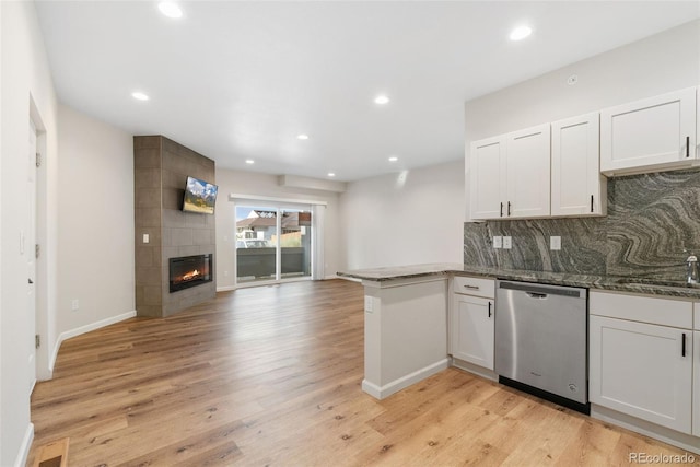 875 E 78th Ave Unit 52, Denver, CO 80229 - kitchen featuring stainless steel dishwasher, a peninsula, backsplash, open floor plan, and light wood-type flooring