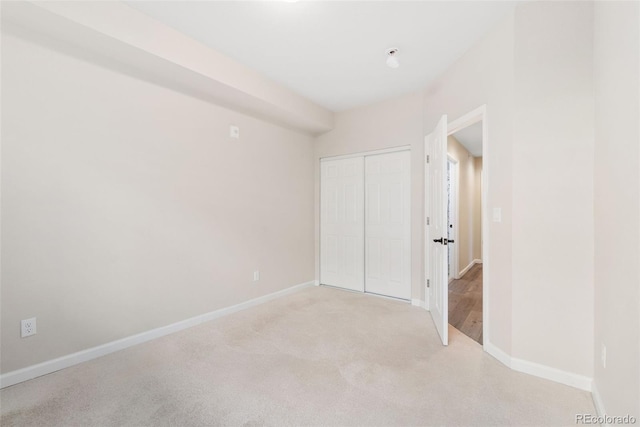 875 E 78th Ave Unit 52, Denver, CO 80229 - unfurnished bedroom with a closet, baseboards, and light carpet