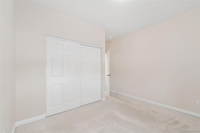 875 E 78th Ave Unit 52, Denver, CO 80229 - unfurnished bedroom with light carpet, baseboards, and a closet