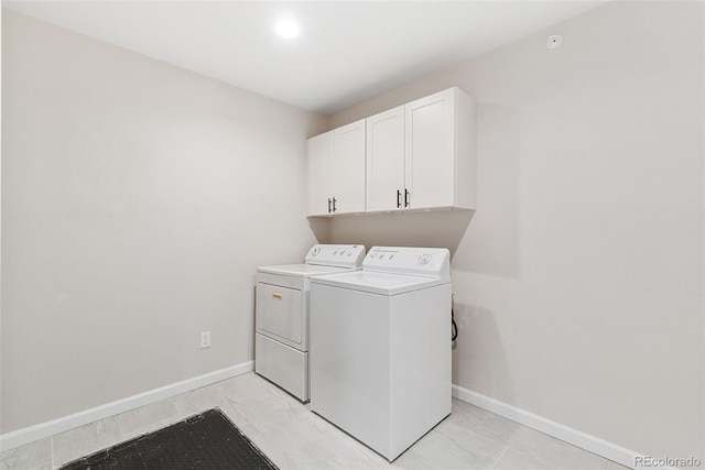 875 E 78th Ave Unit 52, Denver, CO 80229 - clothes washing area with washing machine and clothes dryer, baseboards, and cabinet space