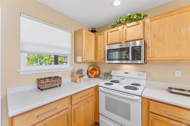 kitchen with electric stove and light brown cabinets