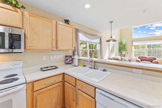 kitchen with light brown cabinetry, a healthy amount of sunlight, white appliances, and sink