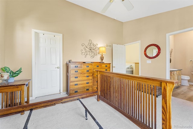 bedroom with connected bathroom, ceiling fan, and light colored carpet