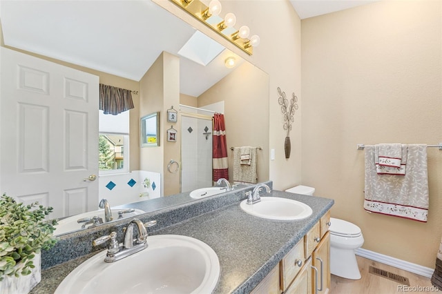 bathroom featuring vanity, vaulted ceiling with skylight, curtained shower, wood-type flooring, and toilet