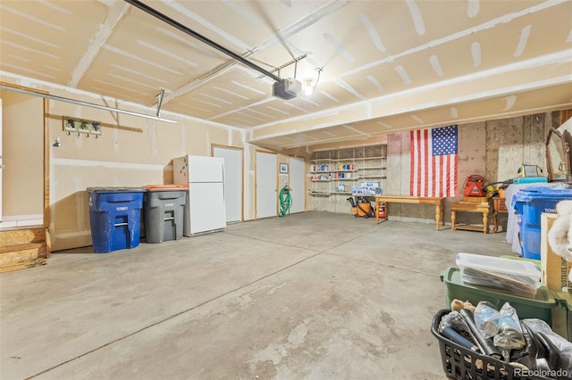 garage with a garage door opener and white fridge