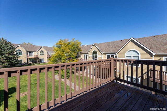 wooden deck featuring a lawn