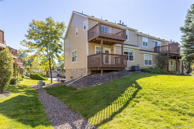 back of property with cooling unit, a balcony, and a yard