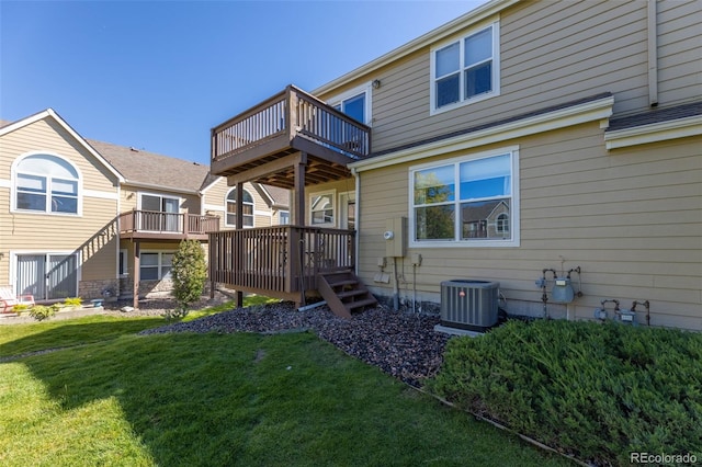 rear view of property featuring a lawn, a wooden deck, and central AC