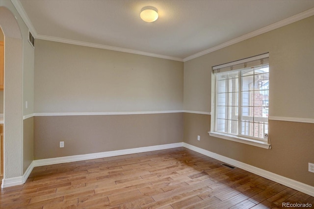 2253 E 100th Pl, Thornton, CO 80229 - unfurnished room with wood finished floors, arched walkways, ornamental molding, and baseboards