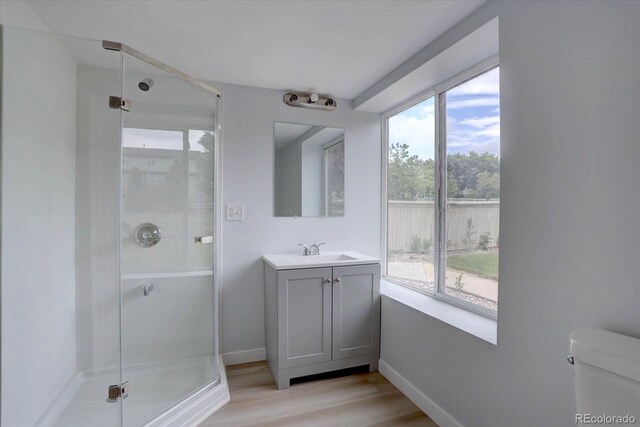 2253 E 100th Pl, Thornton, CO 80229 - bathroom with vanity, a stall shower, wood finished floors, and baseboards