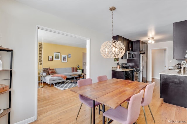 dining space featuring a chandelier and light wood-style floors