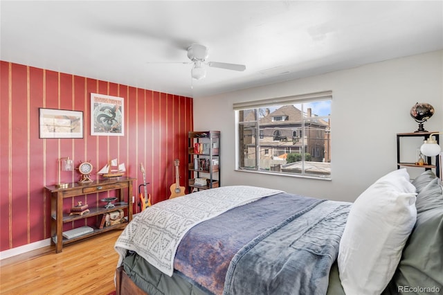 bedroom with baseboards, a ceiling fan, and wood finished floors