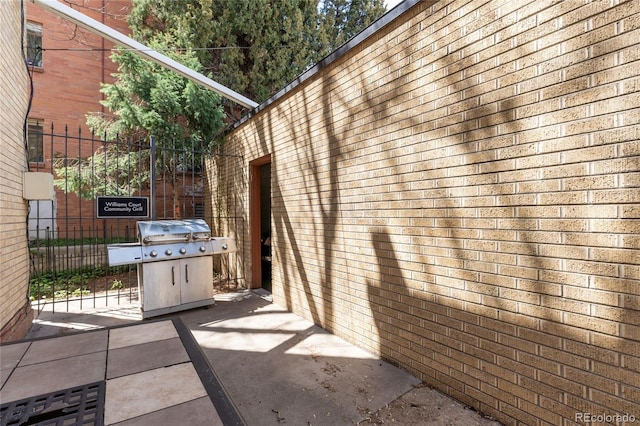 view of side of property featuring fence and brick siding