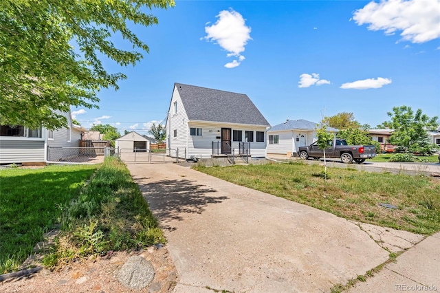 235 S 8th Ave, Brighton, CO 80601 - view of front of house with a gate, an outbuilding, driveway, and a shingled roof