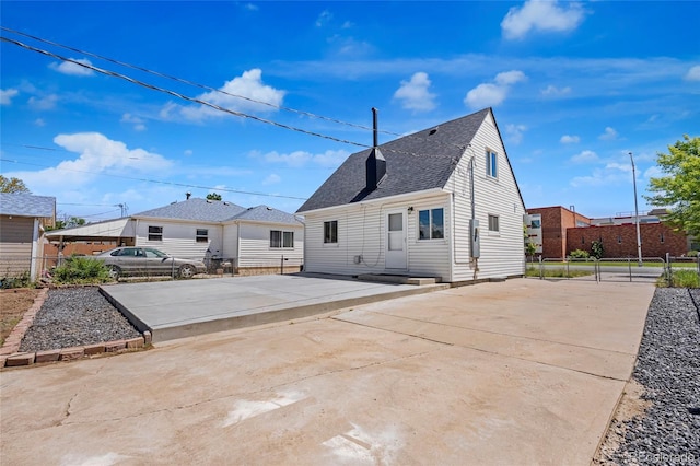 235 S 8th Ave, Brighton, CO 80601 - back of property featuring a shingled roof, a patio area, and driveway