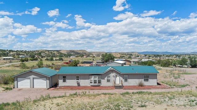 single story home with a mountain view, an outbuilding, and a garage