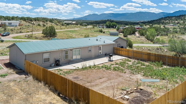 rear view of property featuring a mountain view and a patio