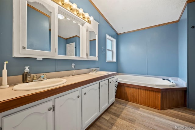 bathroom featuring crown molding, hardwood / wood-style floors, vanity, and lofted ceiling