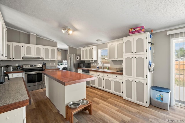 kitchen featuring lofted ceiling, sink, a kitchen island, appliances with stainless steel finishes, and light hardwood / wood-style floors