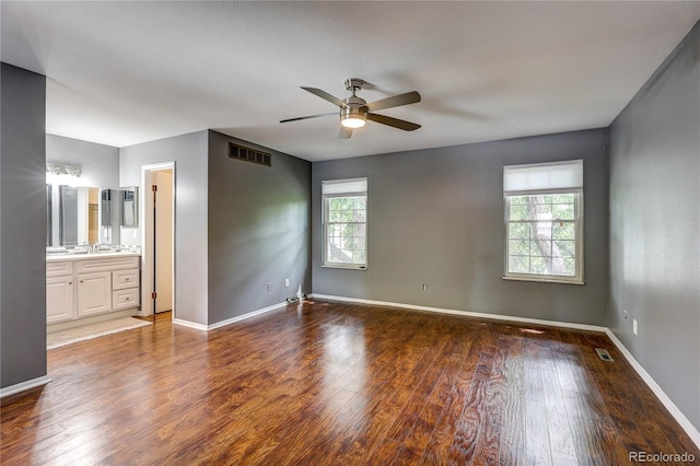 2829 S Xanadu Way, Aurora, CO 80014 - unfurnished bedroom featuring wood finished floors, a ceiling fan, and ensuite bath