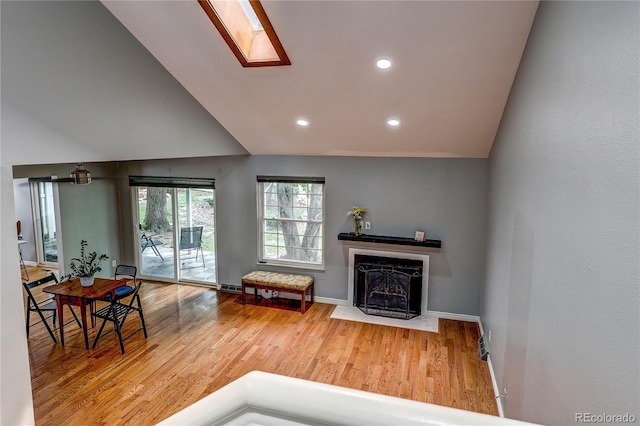 2829 S Xanadu Way, Aurora, CO 80014 - living area with wood finished floors, a fireplace with flush hearth, vaulted ceiling, recessed lighting, and a skylight