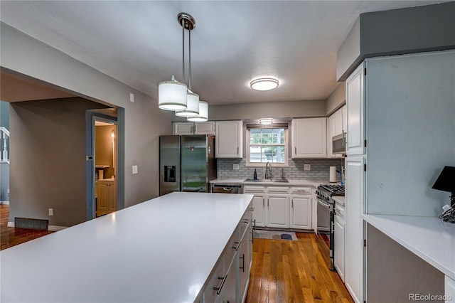 2829 S Xanadu Way, Aurora, CO 80014 - kitchen with stainless steel appliances, decorative backsplash, light countertops, and wood finished floors