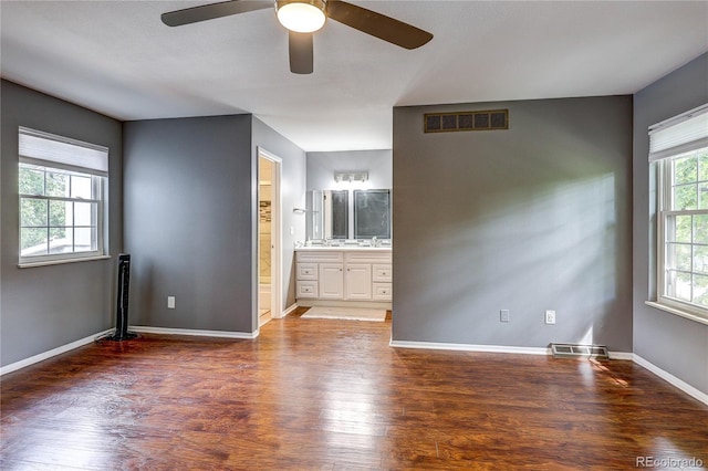 2829 S Xanadu Way, Aurora, CO 80014 - unfurnished bedroom featuring wood finished floors, ensuite bathroom, and a ceiling fan