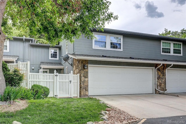2829 S Xanadu Way, Aurora, CO 80014 - townhome / multi-family property with stone siding, a garage, and driveway