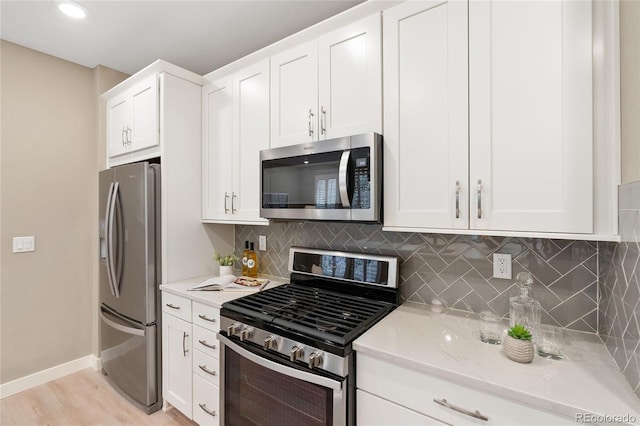 239 W Jamison Ct, Littleton, CO 80120 - kitchen featuring appliances with stainless steel finishes, tasteful backsplash, baseboards, white cabinets, and recessed lighting
