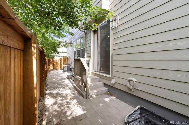 239 W Jamison Ct, Littleton, CO 80120 - view of side of home with cooling unit, a patio area, and entry steps