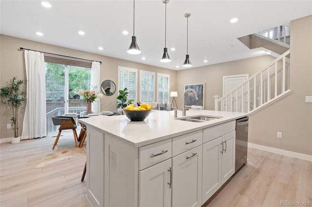 239 W Jamison Ct, Littleton, CO 80120 - kitchen with stainless steel dishwasher, a sink, light wood-style flooring, baseboards, and recessed lighting