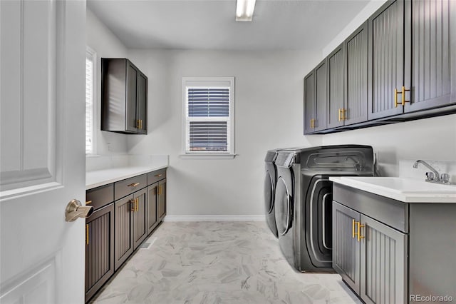 washroom featuring marble finish floor, baseboards, a sink, cabinet space, and independent washer and dryer