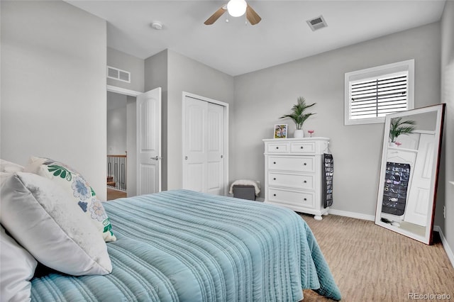 carpeted bedroom with baseboards, ceiling fan, a closet, and visible vents