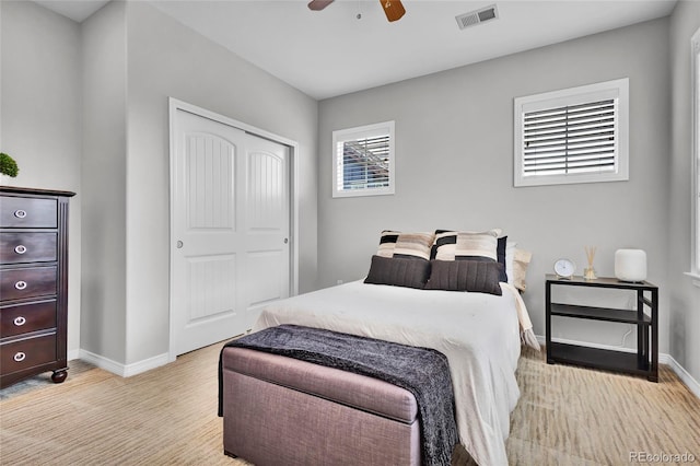 bedroom featuring a ceiling fan, baseboards, visible vents, and a closet