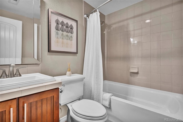 full bath featuring vanity, toilet, a textured wall, and shower / tub combo