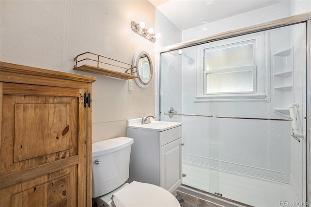full bath featuring toilet, a stall shower, and vanity