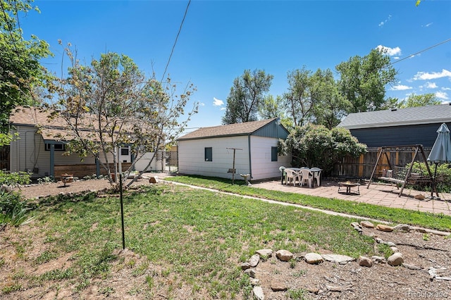 rear view of property featuring a patio area, an outdoor fire pit, and an outdoor structure