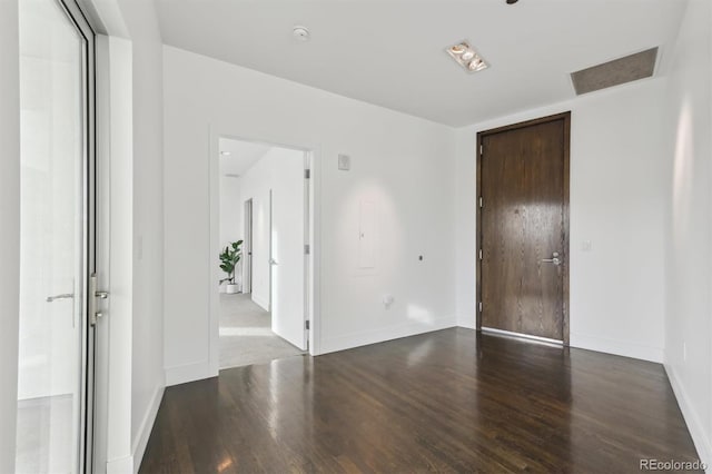 unfurnished room featuring dark wood-type flooring