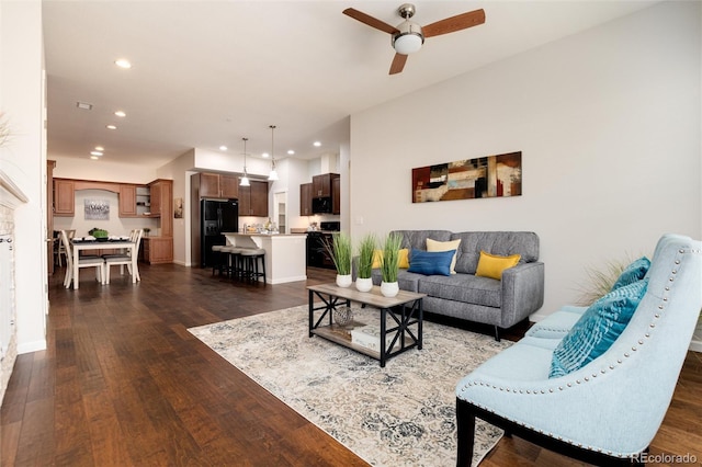 living room with dark wood-type flooring and ceiling fan