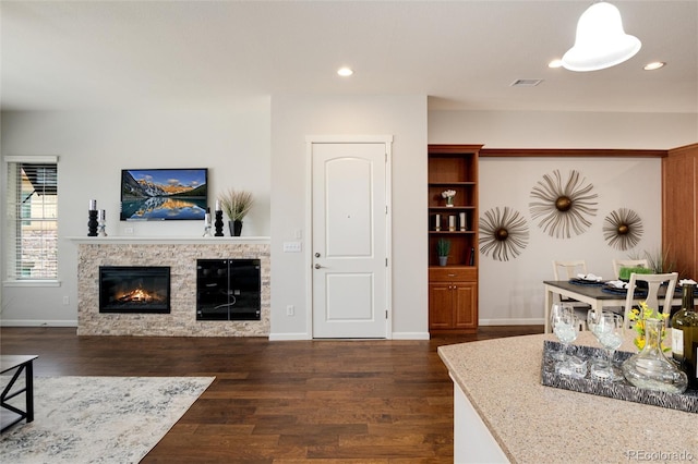 living room with dark wood-type flooring and a fireplace