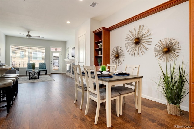 dining area with dark wood-type flooring and ceiling fan