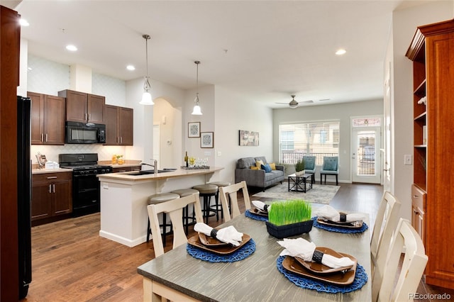 dining room featuring sink, hardwood / wood-style floors, and ceiling fan