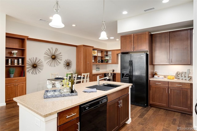 kitchen with pendant lighting, a center island with sink, dark hardwood / wood-style flooring, and black appliances