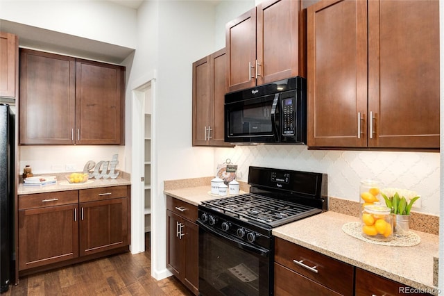 kitchen with tasteful backsplash, dark hardwood / wood-style floors, light stone countertops, and black appliances