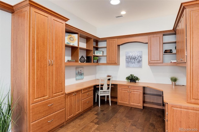 office space featuring dark hardwood / wood-style floors and built in desk