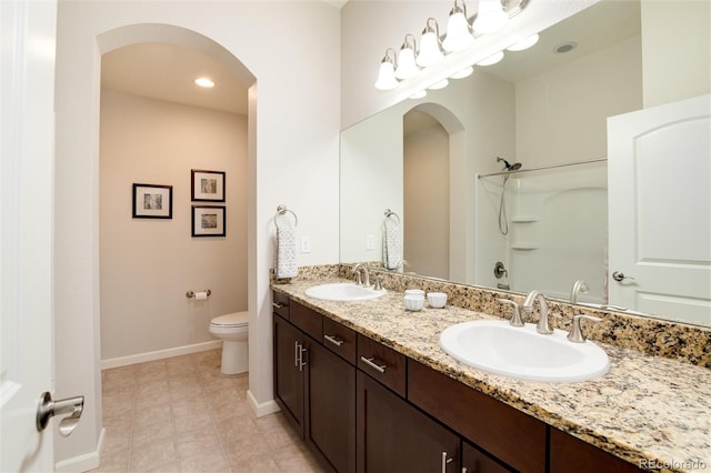 bathroom featuring vanity, walk in shower, tile patterned floors, and toilet