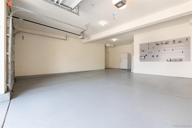 garage featuring a garage door opener and white refrigerator