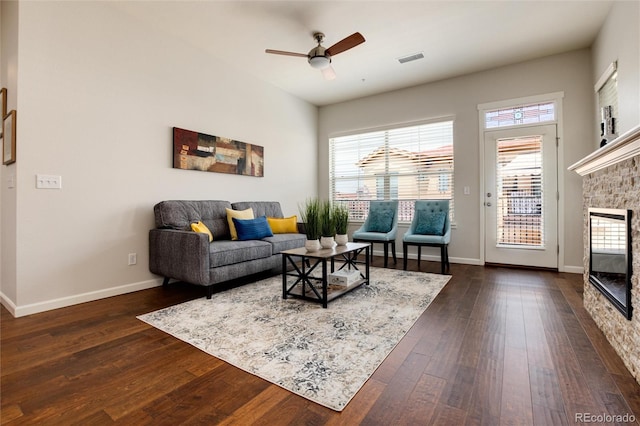 living room with dark hardwood / wood-style flooring, a fireplace, and ceiling fan