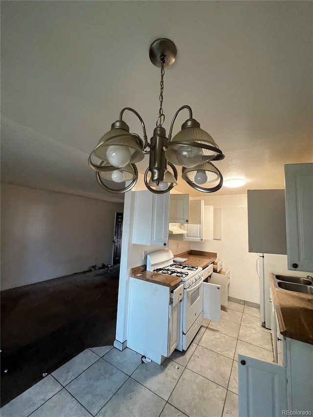 kitchen with sink, light tile patterned flooring, white range with gas cooktop, and white cabinets