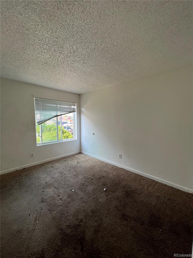 carpeted spare room with a textured ceiling